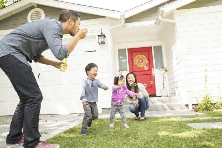 Mid adult couple with two children blowing bubbles